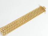 a close up of a gold bracelet on a white surface