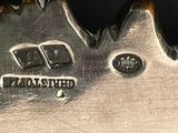 a close up of a silver plate with a bird on it