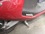 a close up of a red motorcycle parked in a parking lot
