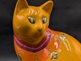 a cat figurine sitting on a black surface