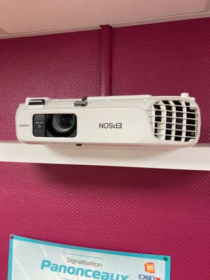 un projecteur posé sur une étagère dans une pièce