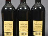 three bottles of red wine sitting next to each other on a table