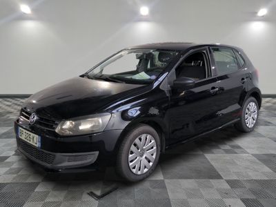 the black volkswagen polo is parked on a checkered tile floor