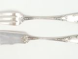 two spoons and a fork on a white surface