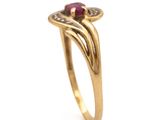 a close up of a gold ring with a ruby stone