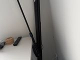 un trépied noir posé sur un bureau blanc, près d'un mur blanc