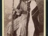 une vieille photo en noir et blanc d'une femme tenant un fusil