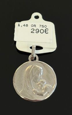 un gros plan d'une médaille d'argent à laquelle est attachée une étiquette