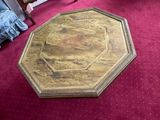 a wooden table with a gold top on a red carpet