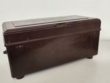 une valise marron posée sur une table blanche