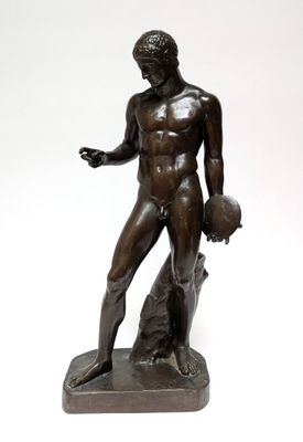 bronze statue of a man holding a ball on a white background
