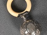 a small silver pocket watch with a wooden ring on it