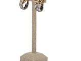 a close up of a pair of earrings on a stand on a white background