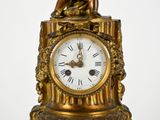 une horloge en or surmontée d'une statue