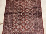 a red and brown rug with a diamond design on it