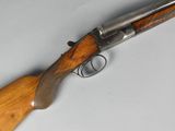 a close up of a rifle with a wooden handle on a table