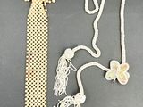 un collier de perles blanches et une cravate blanche posés sur une table