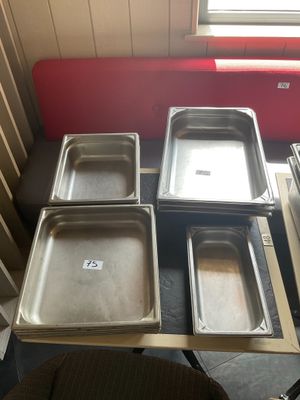 Plusieurs plateaux de nourriture sont posés sur une table dans une cuisine.