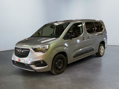 La camionnette argentée est garée dans une pièce aux murs blancs.