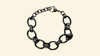 the chain bracelet is made of metal and has a black link