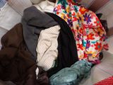 a basket full of clothes that is sitting on a couch