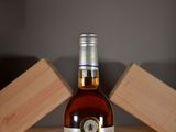 a bottle of alcohol sitting on a table next to wooden blocks