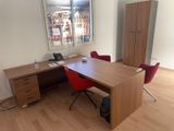 a desk with two chairs and a cabinet in a room