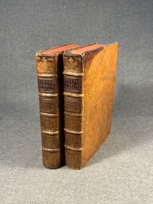 two old books sitting on top of each other on a table