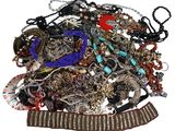 a pile of assorted jewelry on a white surface