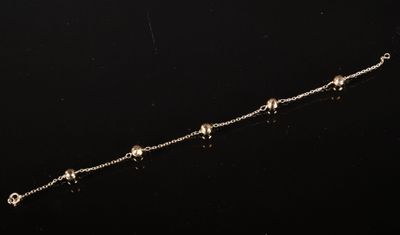 un gros plan d'une chaîne ornée de perles sur un fond noir