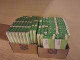 several boxes of green and white boxes on top of a wooden floor