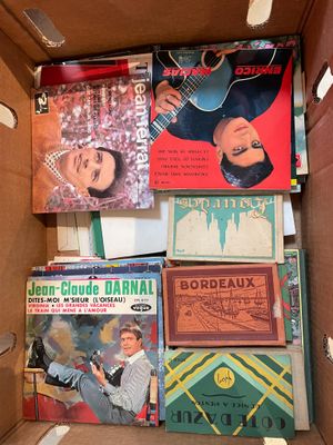 un carton rempli de livres et une guitare