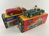 three toy cars are sitting on top of boxes on a white surface