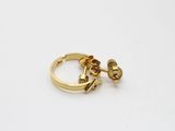 l'image d'une paire de boucles d'oreilles en or sur une surface blanche