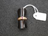 a ring with a pink stone on it sitting on a table