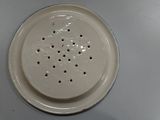 a close up of a white porcelain strainer on a table