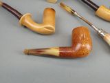 a lot of different types of smoking pipes on the table
