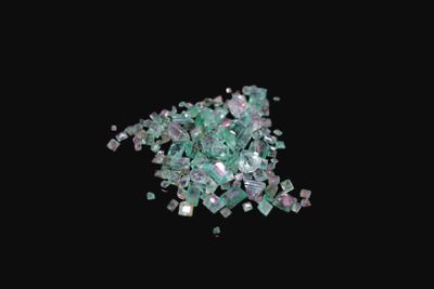 a close up of a pile of broken glass on a black background