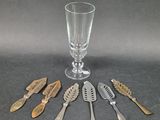 five spoons and a wine glass on the table
