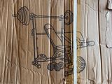 cardboard box with a drawing of a machine on it sitting on a floor