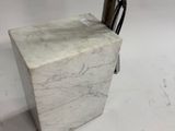 a white marble block with a black handle on a white background