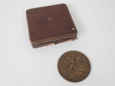 portefeuille en cuir marron avec une pièce de monnaie posée à côté sur une surface blanche