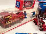 a red fire truck with a ladder next to a box of toys
