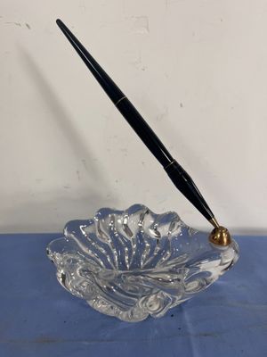 une image représentant un bol en verre contenant un stylo