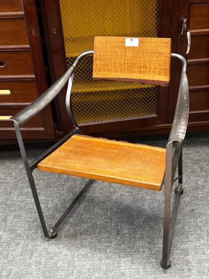 une chaise en métal avec une assise en bois, placée devant une armoire