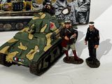 two toy soldiers standing next to a toy tank