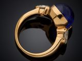 a close up of a gold ring with a blue stone