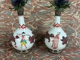 two vases with flowers in them sitting on a table