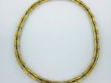 a close up of a gold bracelet on a white surface