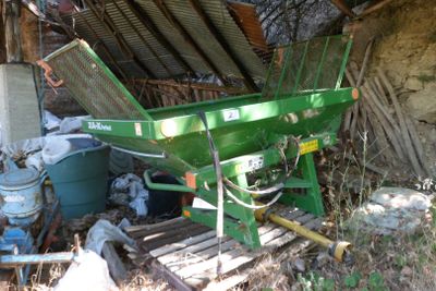 une machine verte posée à côté d'un tas d'ordures